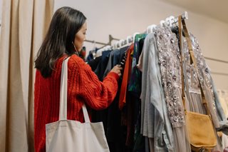 woman shopping off clothes rack