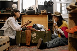 two girls looking through used clothes