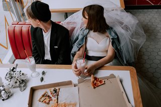 bride and groom eating pizza