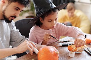 little girl in witch hat painting