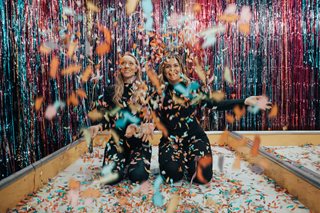 two women throwing confetti into the air