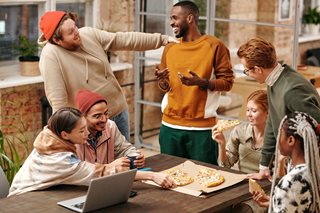 group of friends eating a pizza together