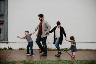 family of four walking on a sidewalk