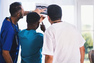 three doctors looking at something