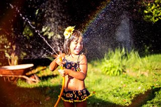 young girl playing with a hose