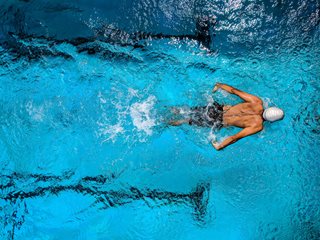 man swimming in pool