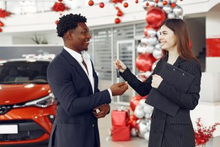 woman handing a set of car keys to a man