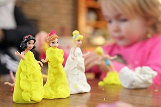 young girl playing with playdough and toys