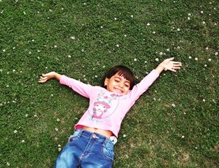kid laying down in grass