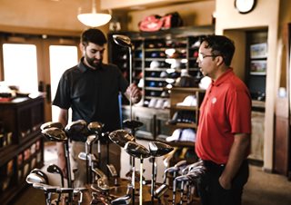 a man selling a golf club to another man