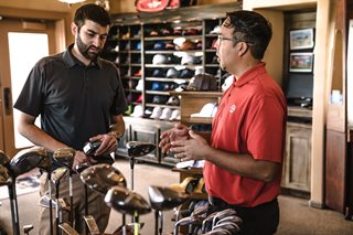 man talking to sales person about golf clubs