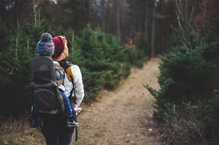 person with child on back hiking
