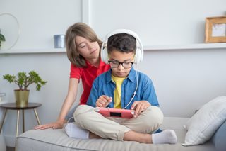 two boys playing on a tablet