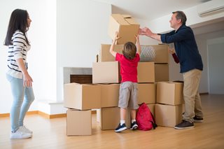 man, young woman, and child stacking moving boxes