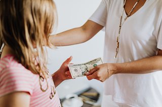 parent giving a child a dollar bill