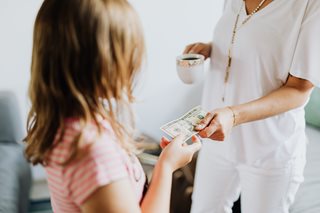 small girl taking money
