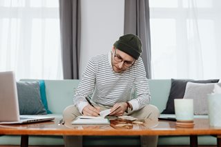man working on his budget in a notebook