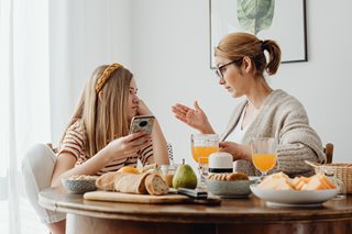 mom and teenager talking while sharing a meal