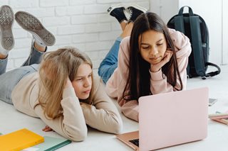 two girls looking at a laptop