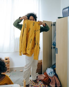 kid holding up a colorful sweater