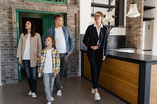 family with real estate agent touring a home