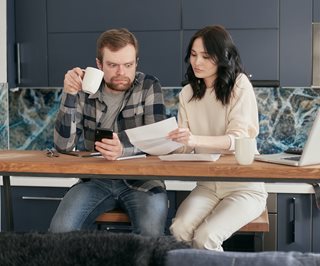shocked man looking at budget with wife