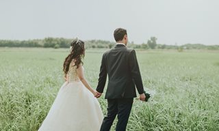 bride and groom in grass field
