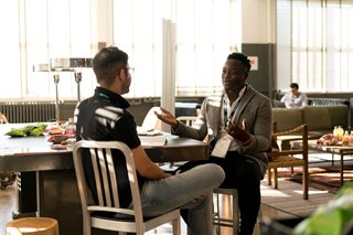 two men talking with each other at a table