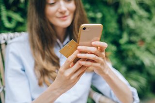 woman holding phone and debit card