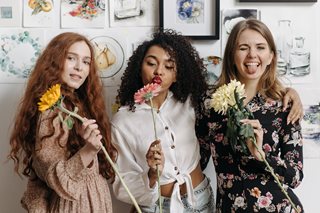 three women posing with flowers