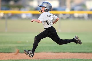young boy in a baseball uniform running