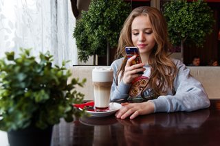 woman with coffee and a cell phone
