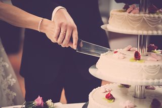 man and woman cutting a wedding cake