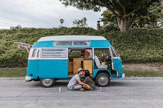 couple kissing in front of their van
