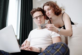 man and woman looking at credit card