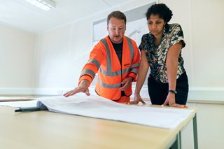 woman talking with contractor looking at blueprints