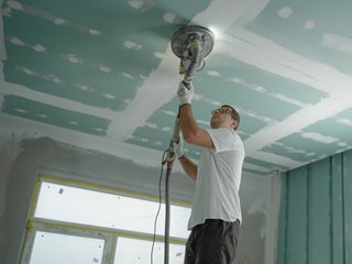 man installing a light in a home