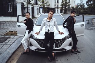 three teens leaning against a car