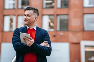 man in suit jacket with tablet