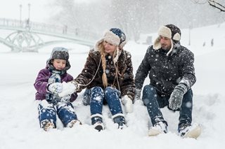 parents with a child in a snowstorm