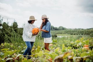 two woman holding a pumpkin